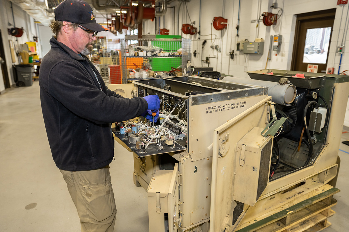 Photo of employee working on a generator